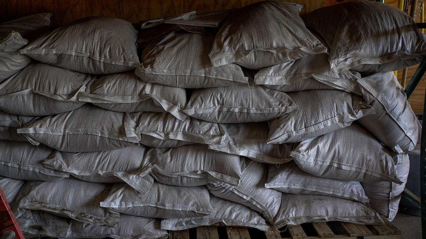 Photo showing a large stack of seed bags at the NDF seedbank warehouse.