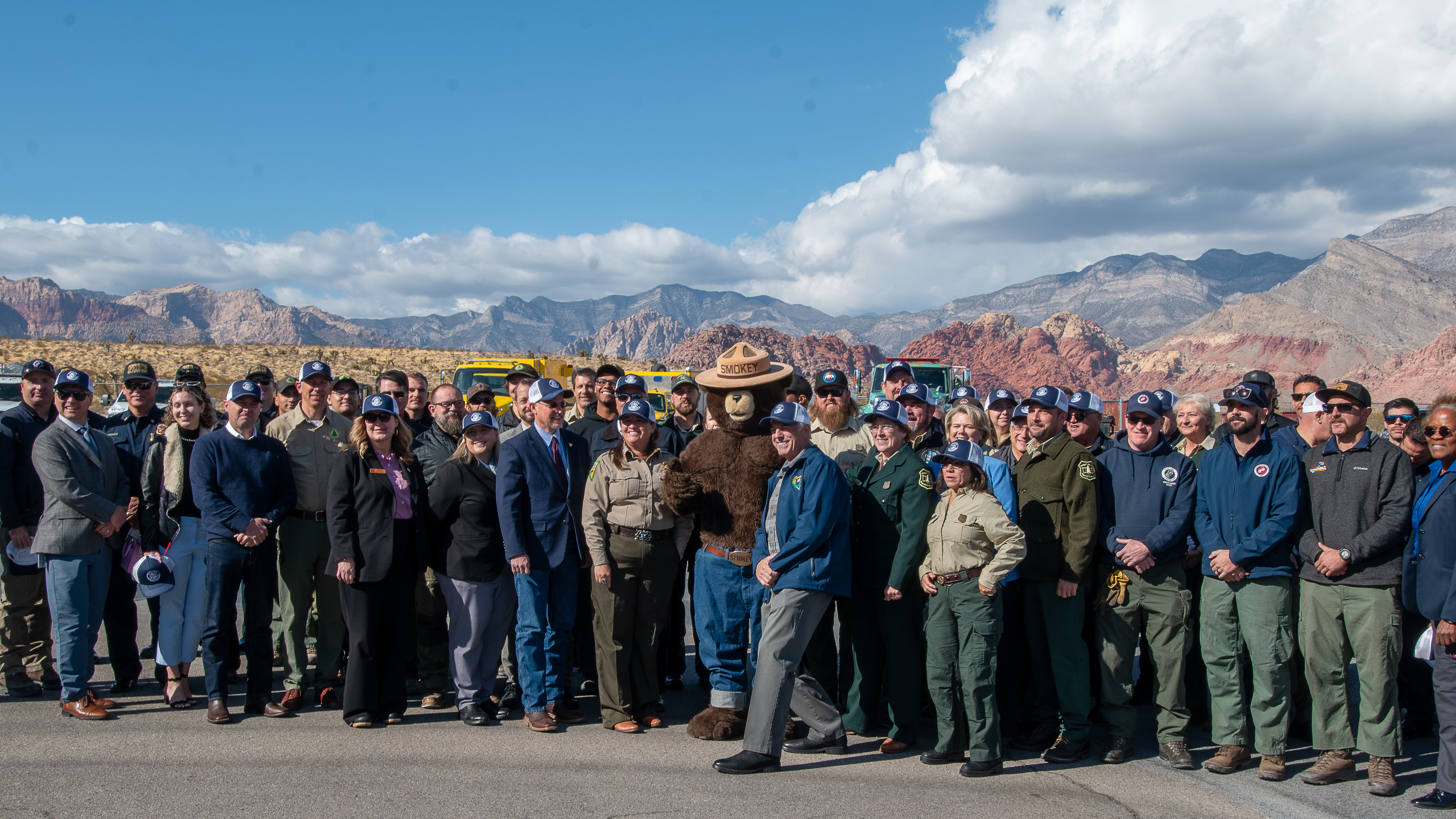 Governor Lombardo, guests and signatories of the Shared Stewardship agreement pose for a group photo with Smokey Bear at Red Rock Canyon